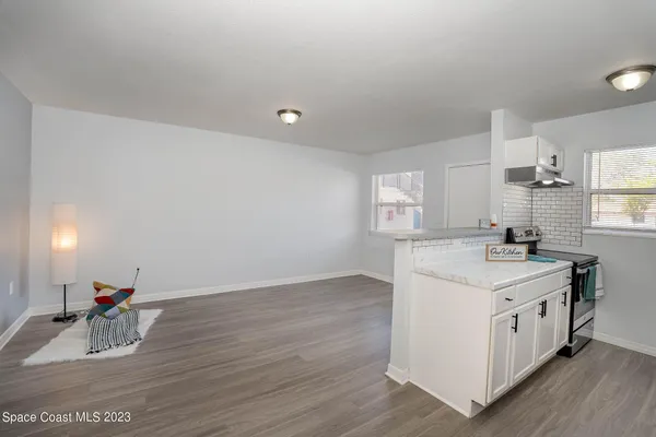 a kitchen with a sink cabinets and wooden floor