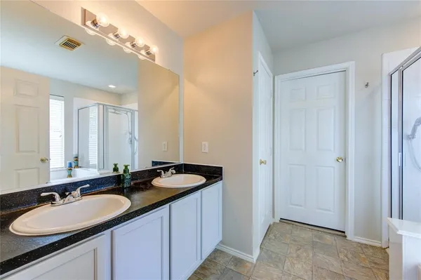 a bathroom with a double vanity sink and a mirror