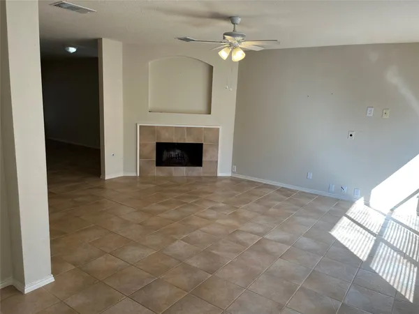en empty room with windows and fireplace