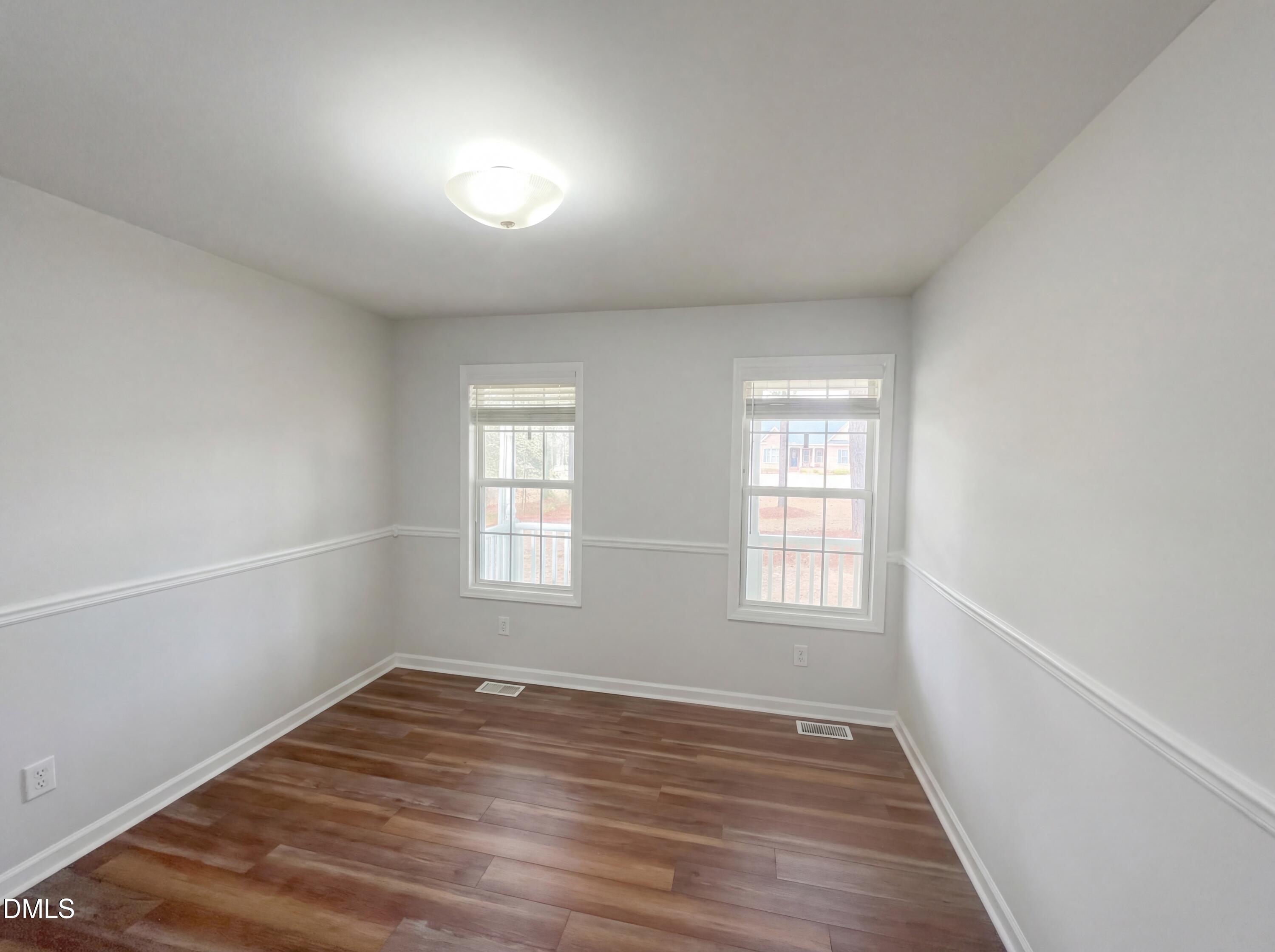 299 Greenleaf Road Angier, NC 27501 - Photo 11 of 15 an empty room with wooden floor and windows