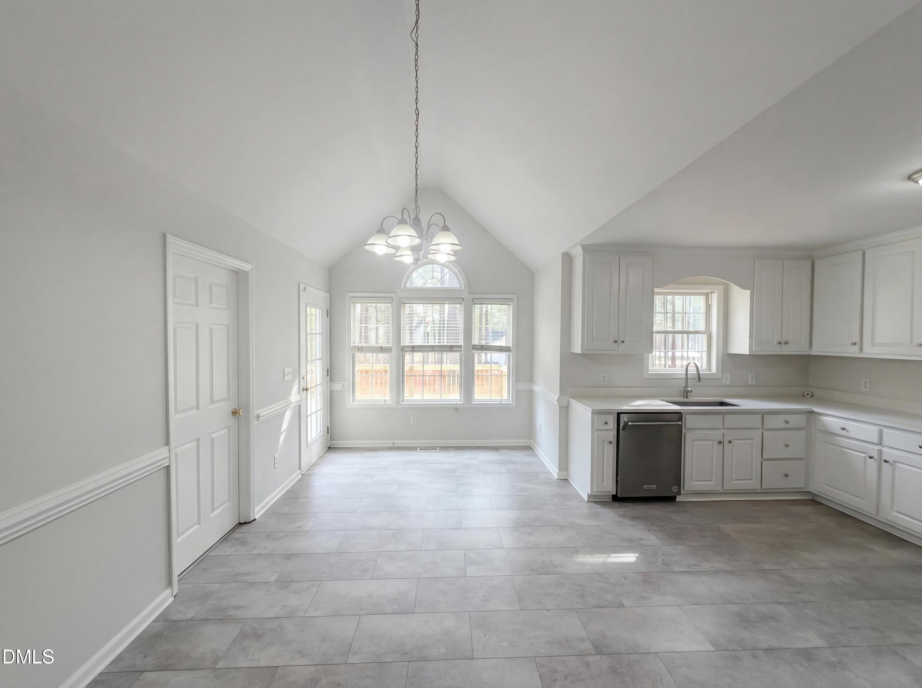 299 Greenleaf Road Angier, NC 27501 - Photo 10 of 15 a large white kitchen with granite countertop a sink dishwasher a stove and white cabinets with wooden floor