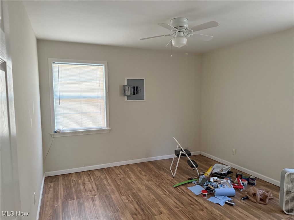 1877 Clyde Road Madison, OH 44057 - Photo 8 of 19 Empty room with wood finished floors, electric panel, and ceiling fan