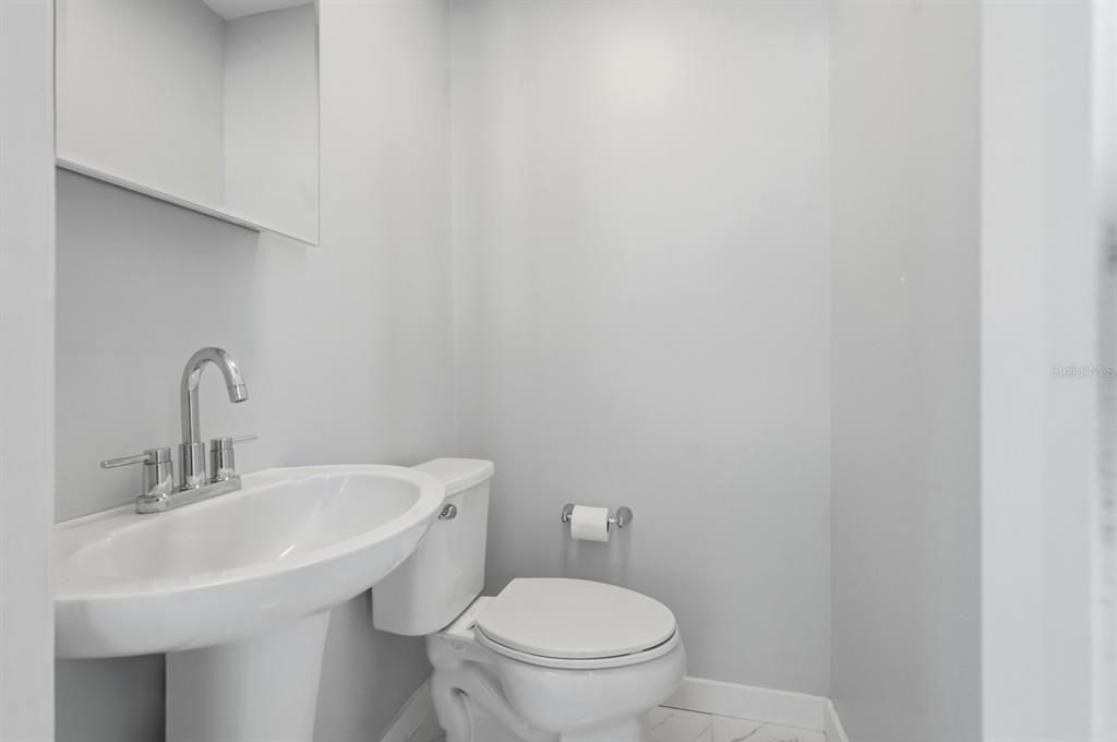 231 North Ridgewood Avenue Ormond Beach, FL 32174 - Photo 25 of 52 a bathroom with a sink a toilet and a mirror