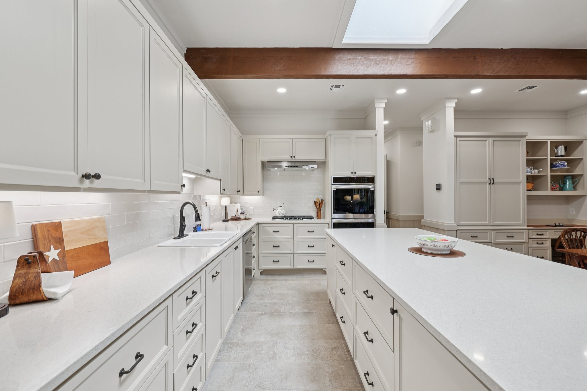 546 McAllister Road Bastrop, TX 78602 - Photo 14 of 40 Kitchen with white cabinetry, ornamental molding, a skylight, backsplash, and light stone counters