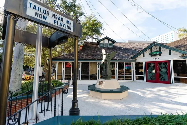 front view of a house with a large window and potted plants