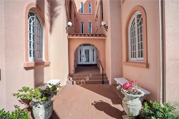 a view of an entryway with a flower pot and a rug