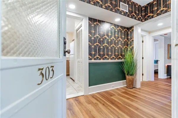 a view of a hallway with wooden floor and a dining table