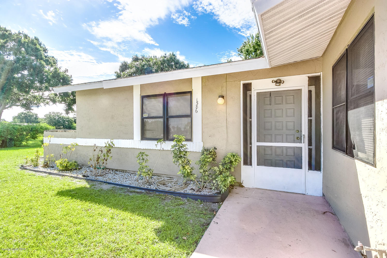 1586 Creel Road Northeast Palm Bay, FL 32905 - Photo 2 of 21 a front view of a house with garden