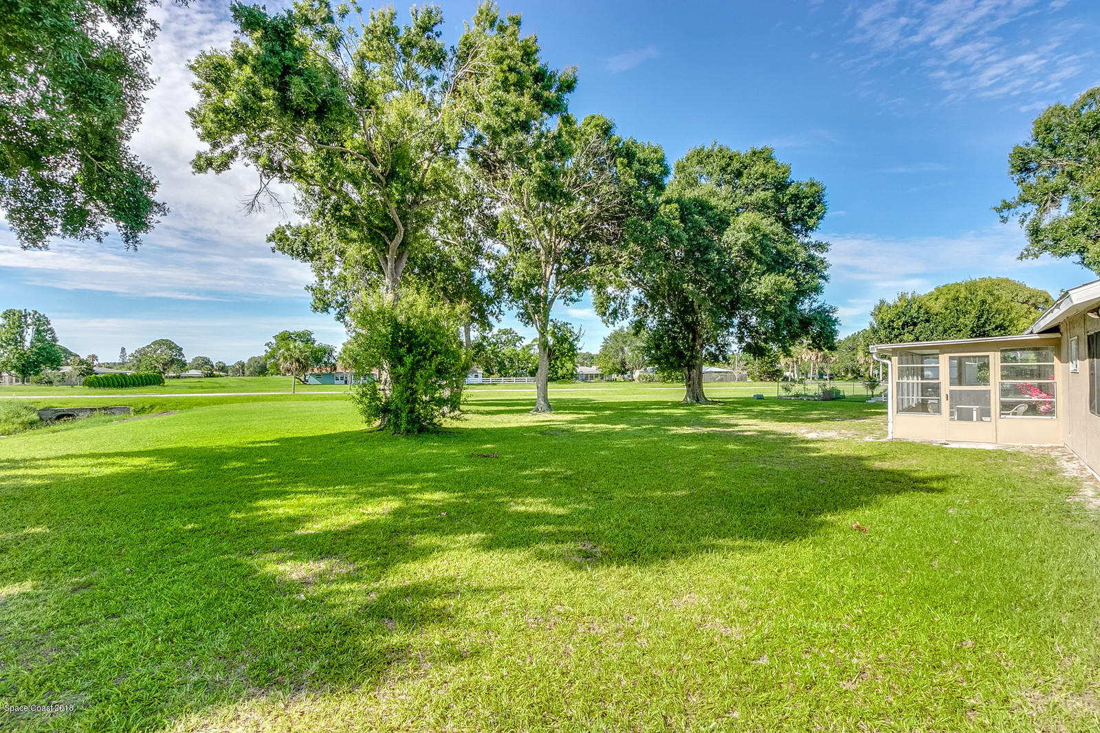 1586 Creel Road Northeast Palm Bay, FL 32905 - Photo 20 of 21 a view of a grassy field with trees