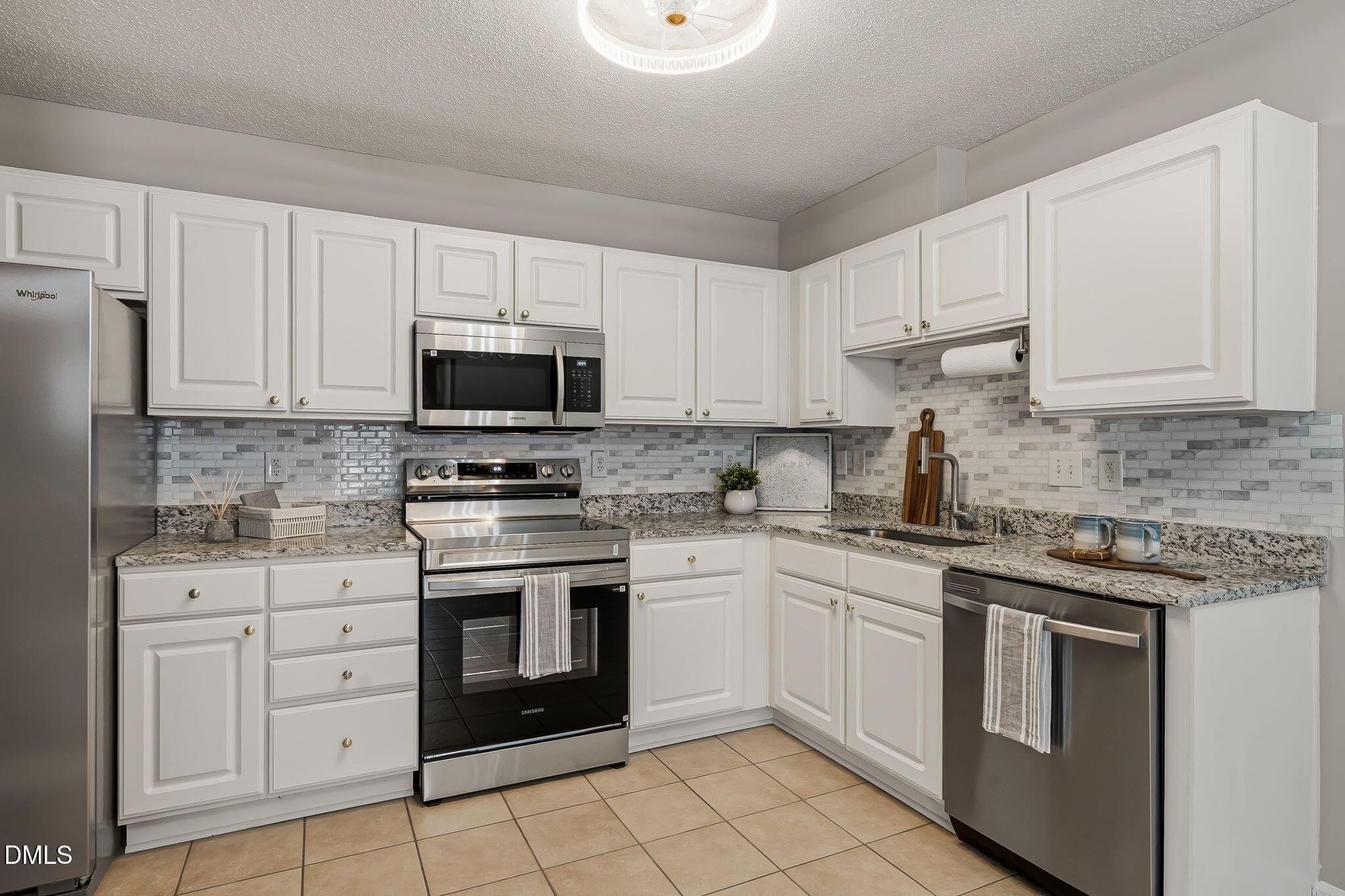 2501 Huntscroft Lane, Unit 100 Raleigh, NC 27617 - Photo 12 of 31 a kitchen with white cabinets appliances and sink