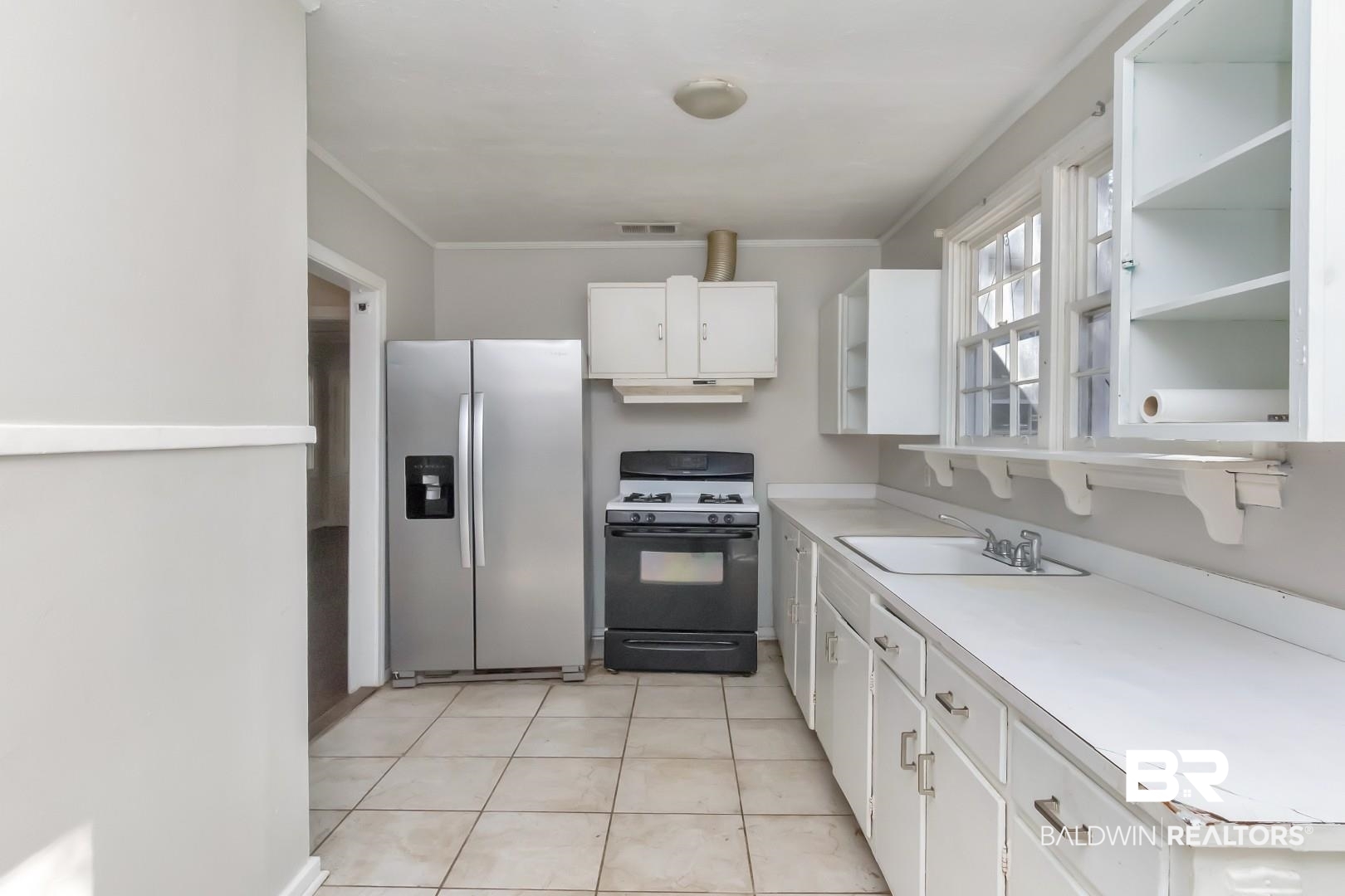 5001 Hillwood Circle South Mobile, AL 36608 - Photo 12 of 20 Kitchen featuring stainless steel fridge, visible vents, range with gas cooktop, under cabinet range hood, and a sink
