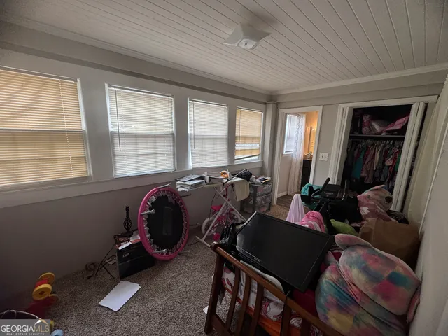 a view of a hallway and a livingroom with furniture