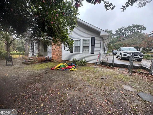 a view of a house with backyard and sitting area