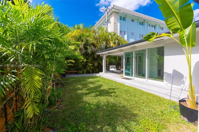 a view of a house with a small yard and floor to ceiling window