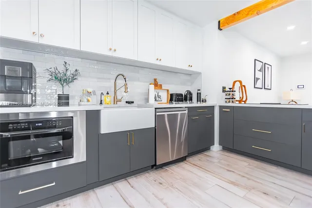 a kitchen with stainless steel appliances granite countertop a stove cabinets and wooden floor