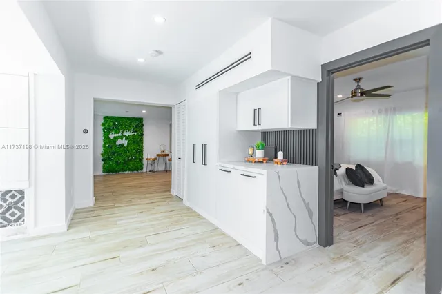 a large white kitchen with cabinets and a couch