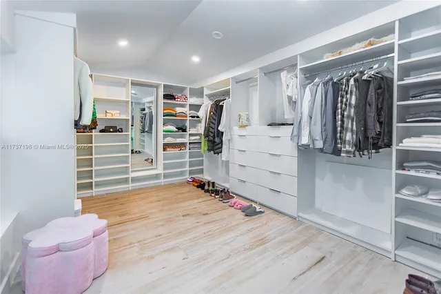 a view of walk in closet with clothes and shoes