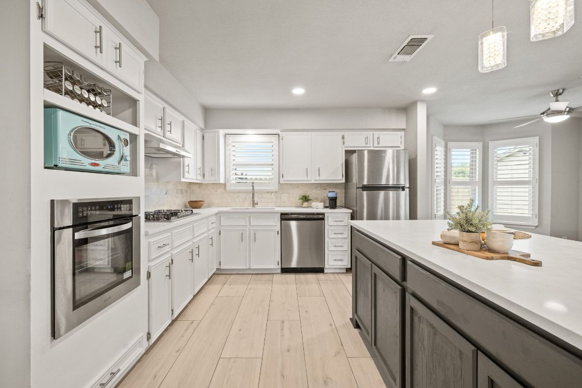 1805 Ryon Cove Round Rock, TX 78681 - Photo 11 of 23 a kitchen with a sink stove and cabinets