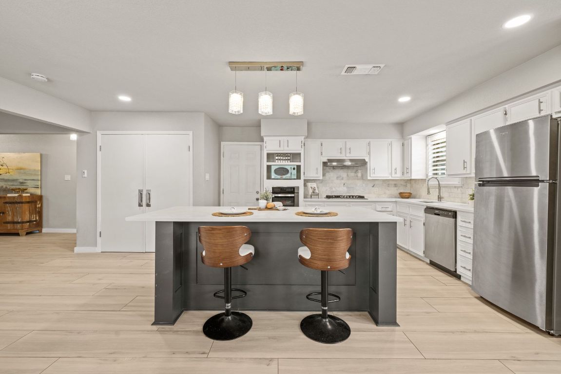 1805 Ryon Cove Round Rock, TX 78681 - Photo 3 of 23 a kitchen with a sink stainless steel appliances and white cabinets