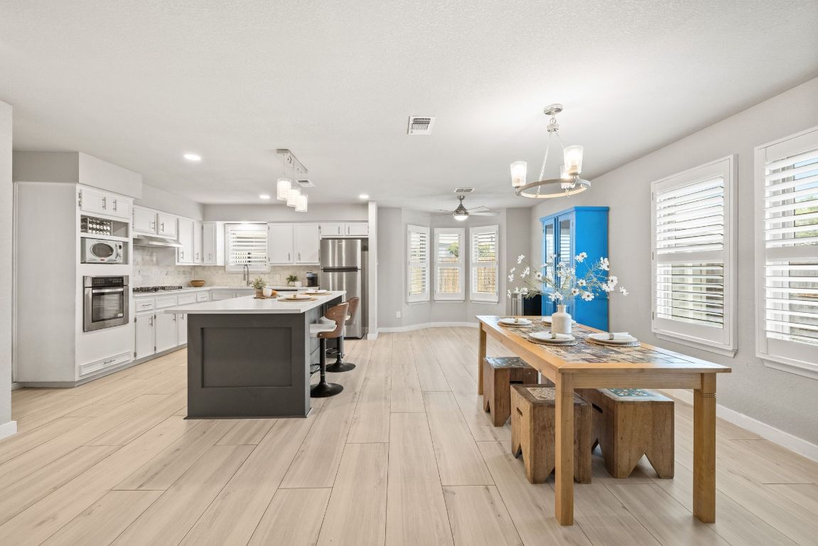 1805 Ryon Cove Round Rock, TX 78681 - Photo 9 of 23 a kitchen with kitchen island a sink a stove and a refrigerator