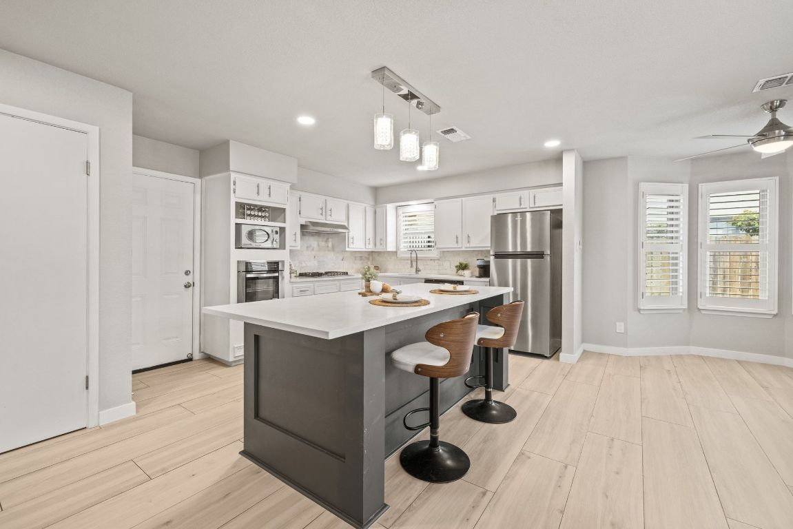 1805 Ryon Cove Round Rock, TX 78681 - Photo 10 of 23 a kitchen with kitchen island stainless steel appliances a sink stove and refrigerator