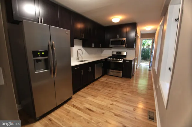 a kitchen with stainless steel appliances granite countertop a refrigerator and a sink