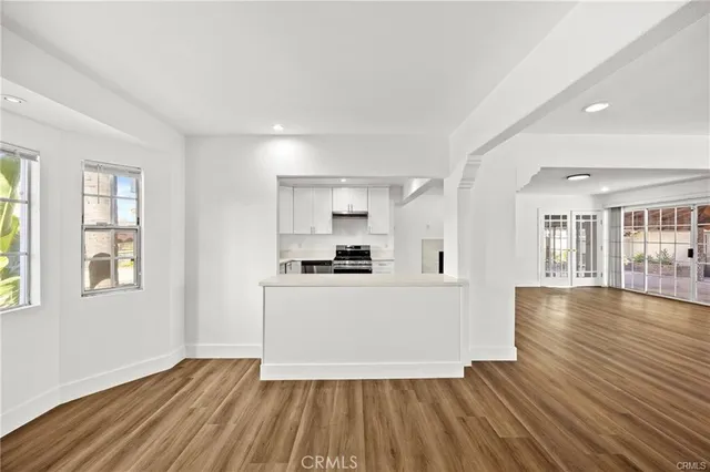 a view of a kitchen with wooden floor and a window
