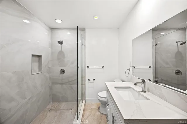 a bathroom with a sink a toilet and shower