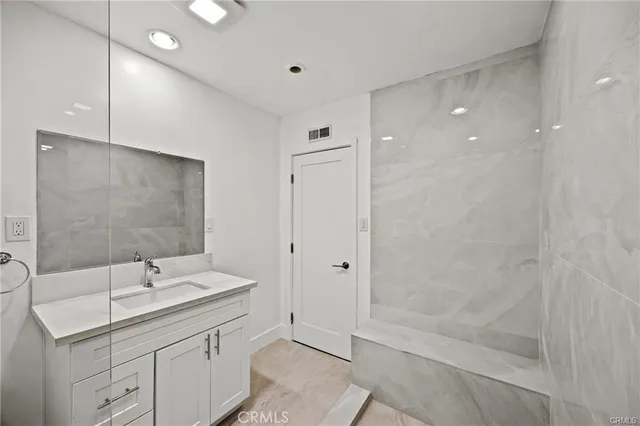 a bathroom with a shower sink and mirror