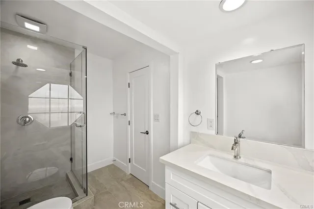 a bathroom with a shower sink and mirror