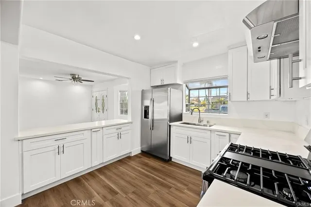 a kitchen with white cabinets and appliances