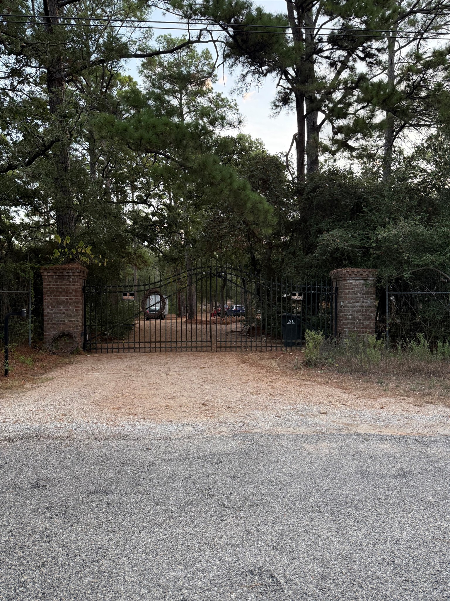 363 Porter Road Bastrop, TX 78602 - Photo 2 of 37 Mature trees frame a private gated entrance accented by classic brick pillars.