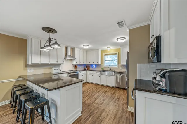 a kitchen with a sink cabinets and wooden floor