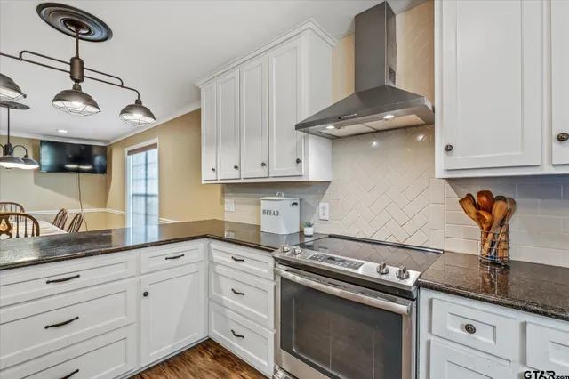 a kitchen with stainless steel appliances granite countertop a sink a stove and cabinets