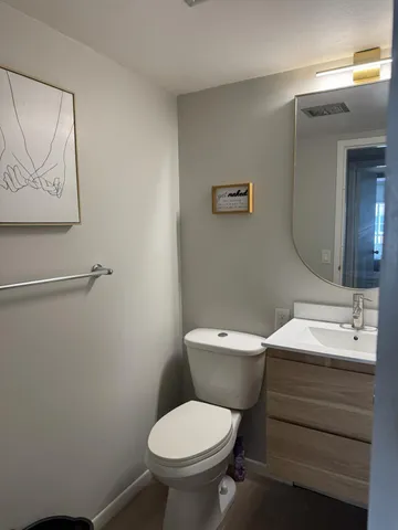 a bathroom with a toilet sink and mirror