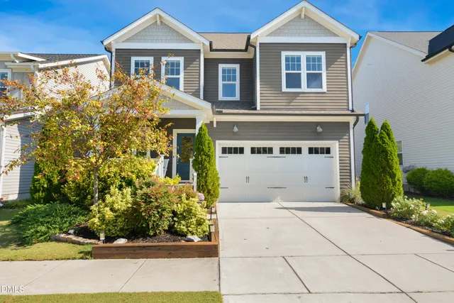 a front view of a house with a yard and potted plants
