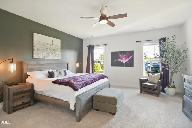 a spacious bedroom with a bed a couch and a chandelier