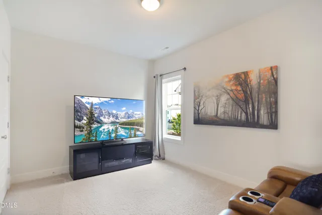 an outdoor living room with furniture and a flat screen tv