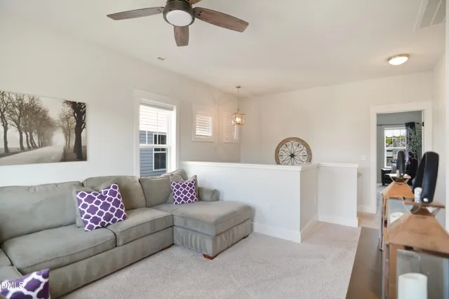 a living room with furniture a clock and a flat screen tv