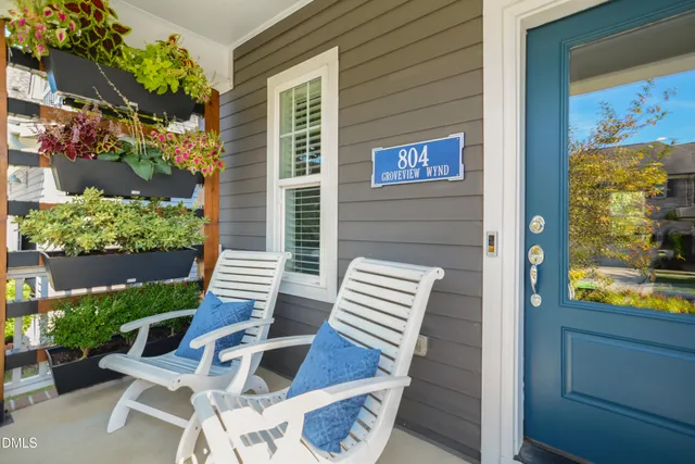 a backyard of a house with wooden floor and outdoor seating