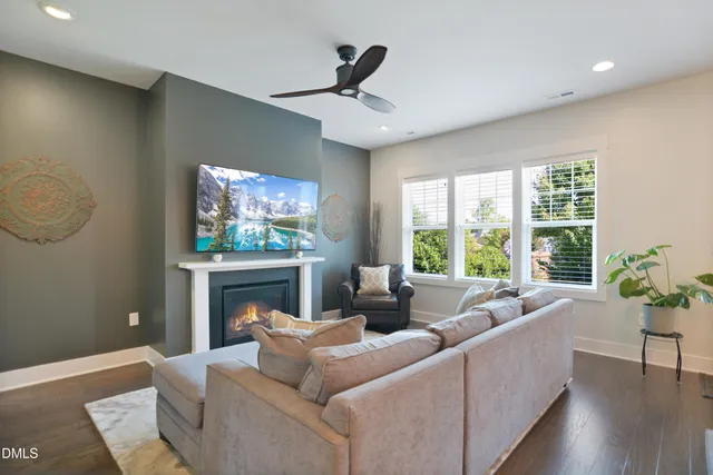 a living room with furniture a fireplace and a flat screen tv
