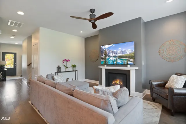 a living room with furniture a fireplace and a flat screen tv