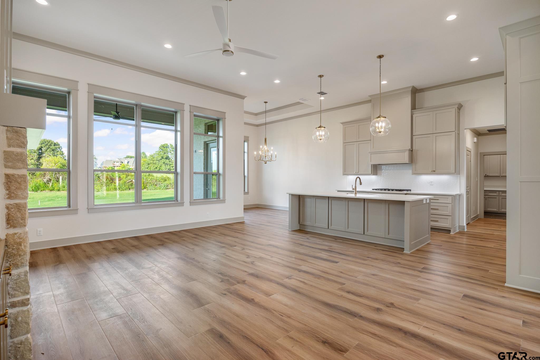 11410 Tucker Circle Flint, TX 75762 - Photo 13 of 43 a large hall with kitchen island granite countertop cabinets and wooden floor