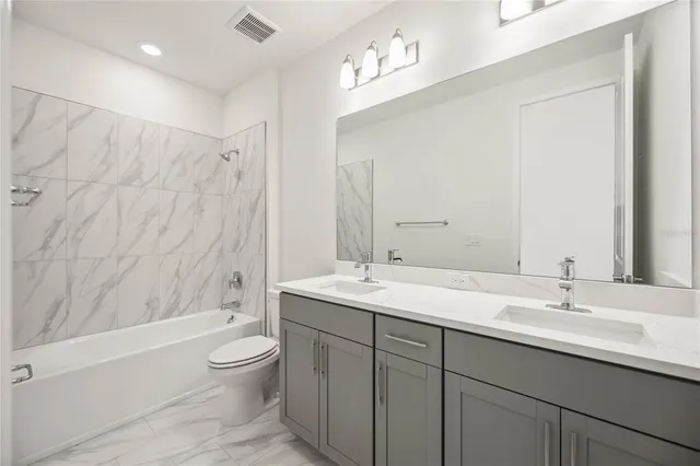 a bathroom with a double vanity sink toilet and shower