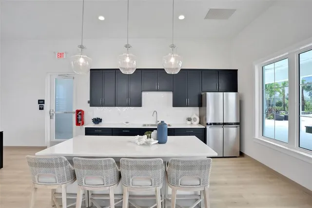 a kitchen with a dining table chairs and a refrigerator
