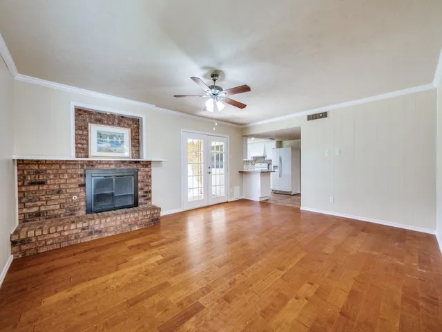 a view of an empty room with a fireplace and a window