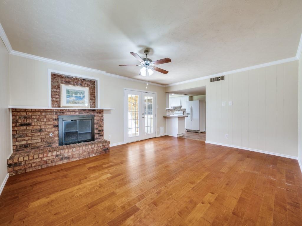 5044 Brandenburg Lane The Colony, TX 75056 - Photo 16 of 33 living room with brick wood burning fireplace with gas starter for ease of use. Easy access onto the covered patio through double french doors.