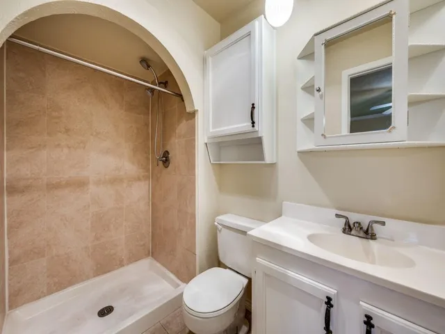 a bathroom with a sink a toilet and shower