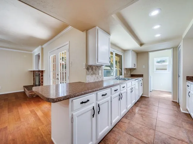 a kitchen with granite countertop a sink and a refrigerator