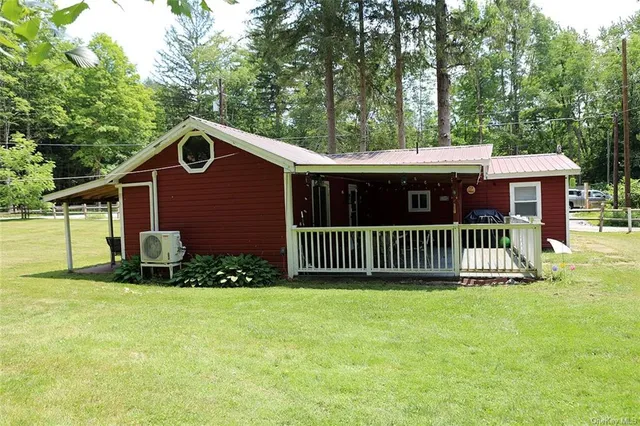 a view of a house with a yard and large tree